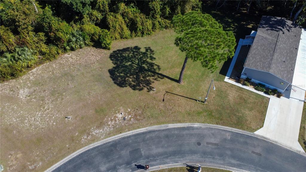 An aerial view shows a vacant residential lot next to a house with a driveway — FOREST GLENN DRIVE, SPRING HILL, FL