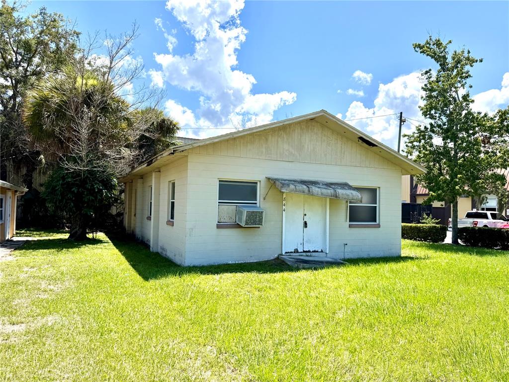 A single-story, light-colored concrete block house with a metal awning over the front doors — 844 KLONDIKE STREET, WINTER GARDEN, FL