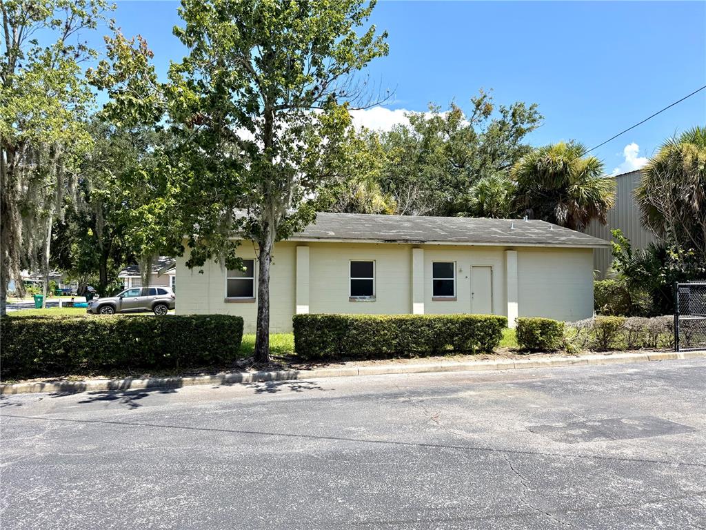 A single-story, light-colored building with a flat roof sits behind a manicured hedge — 844 KLONDIKE STREET, WINTER GARDEN, FL