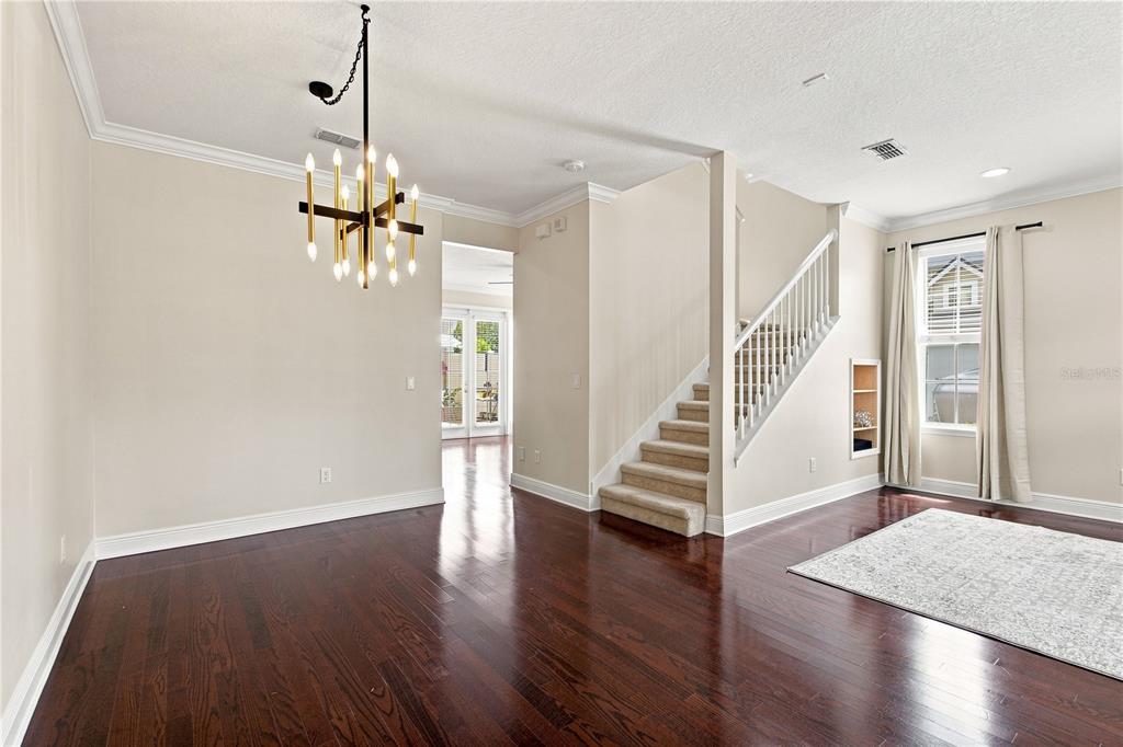 A dining area with a chandelier, hardwood floors, and a staircase leading to an upper level — 1259 INDIANA AVENUE, WINTER PARK, FL
