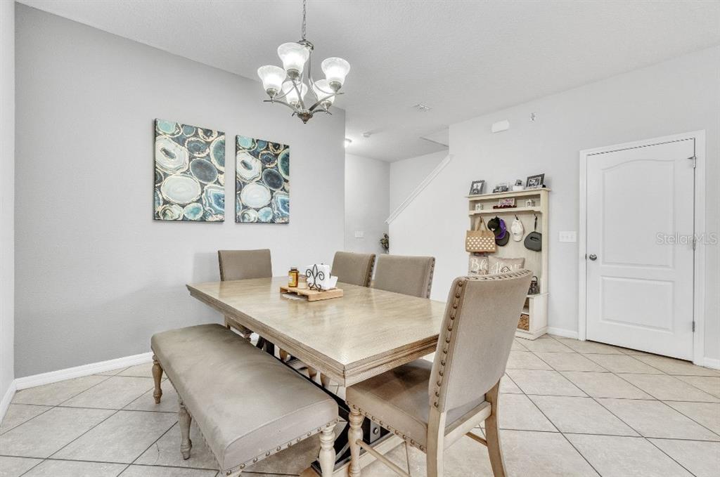 A dining room features a wooden table, upholstered chairs, a bench, and a chandelier — 3256 RODRICK CIRCLE, ORLANDO, FL