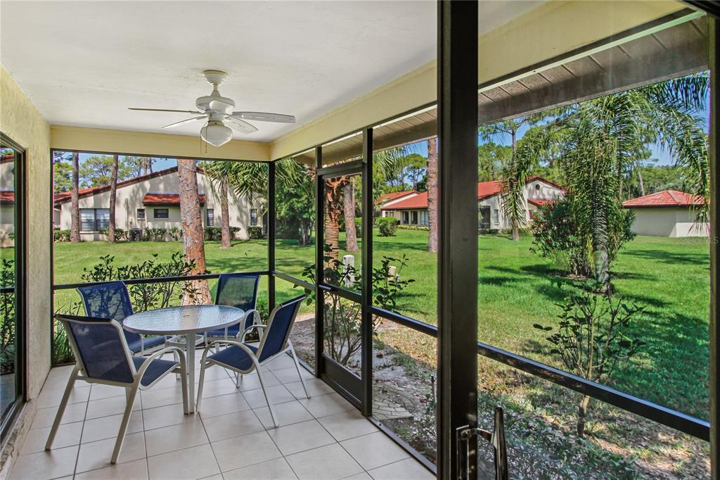 A screened-in patio with tile flooring, a ceiling fan, and a view of the lawn — 3715 PINECONE COURT UNIT 169, SARASOTA, FL