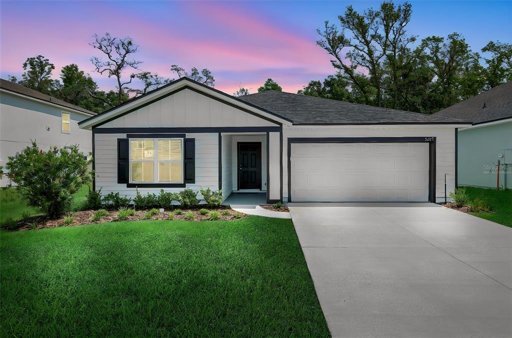 A single-story house with white siding, a dark roof, and a two-car garage — 3622 BELSTEAD WAY, ORANGE PARK, FL