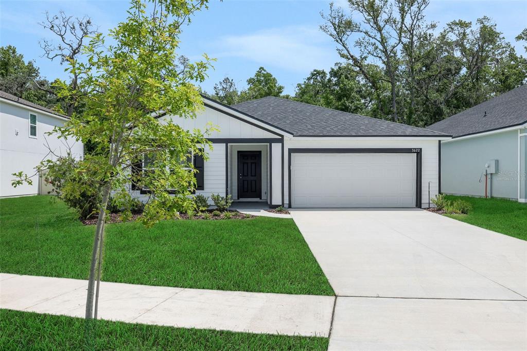A single-story house with white siding, a black front door, and a two-car garage — 3622 BELSTEAD WAY, ORANGE PARK, FL