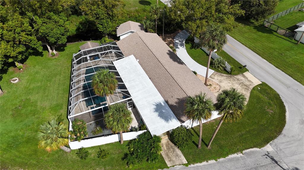 A single-story house with a light green garage door and a white vinyl privacy fence — 11230 SE TIMUCUAN ROAD, SUMMERFIELD, FL