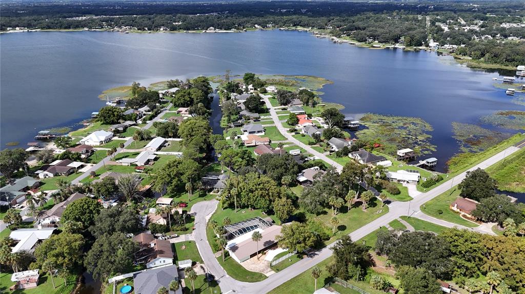 A single-story house with a white exterior, a green garage door, and a concrete driveway — 11230 SE TIMUCUAN ROAD, SUMMERFIELD, FL