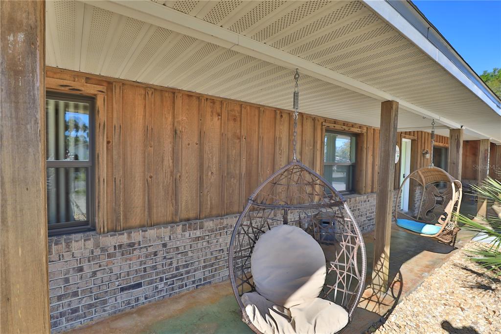 A single-story house with a light green garage door and a white vinyl privacy fence — 11230 SE TIMUCUAN ROAD, SUMMERFIELD, FL