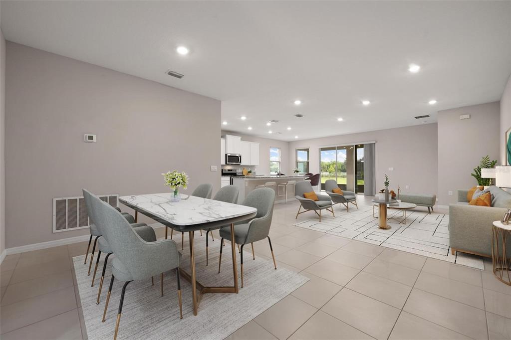 This open-concept living room and kitchen features white cabinetry, stainless appliances, and tile flooring — 431 158TH STREET E, BRADENTON, FL