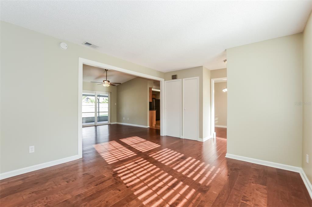 An interior view of a living room with hardwood floors, white doors, and a doorway — 5409 ALBERT DRIVE, WINTER PARK, FL
