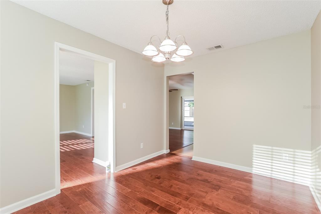 A dining room with hardwood floors, a chandelier, and doorways leading to other rooms — 5409 ALBERT DRIVE, WINTER PARK, FL