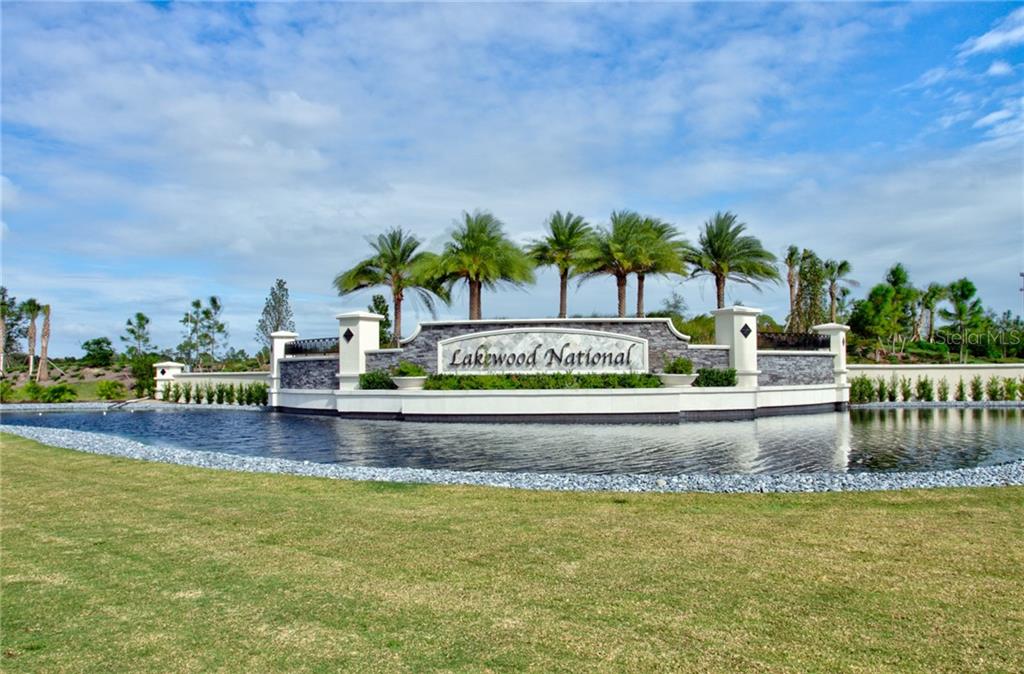 A stone monument sign for Lakewood National stands behind a pond and grassy lawn — 5558 PALMER CIRCLE UNIT 106, BRADENTON, FL