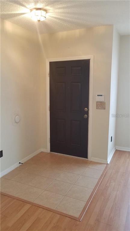 An entryway features a dark front door, light-colored walls, and a tiled floor transition — 6241 OSPREY LAKE CIRCLE, RIVERVIEW, FL