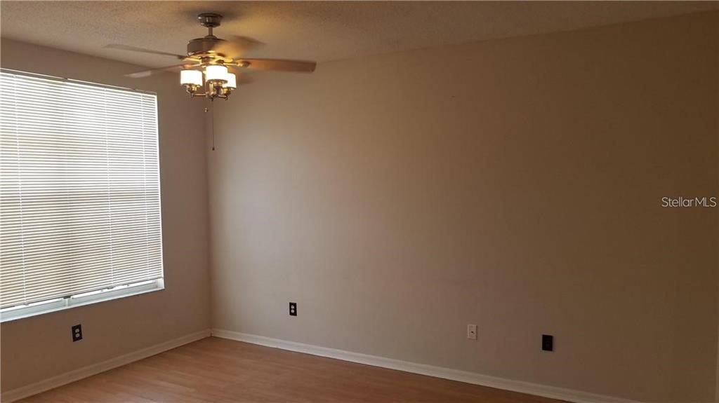 An empty room features light-colored walls, wood-look flooring, a ceiling fan, and a window — 6241 OSPREY LAKE CIRCLE, RIVERVIEW, FL