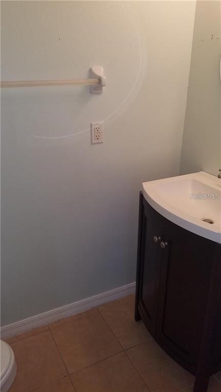 A bathroom features a dark wood vanity with a white sink and a wall-mounted towel bar — 6241 OSPREY LAKE CIRCLE, RIVERVIEW, FL