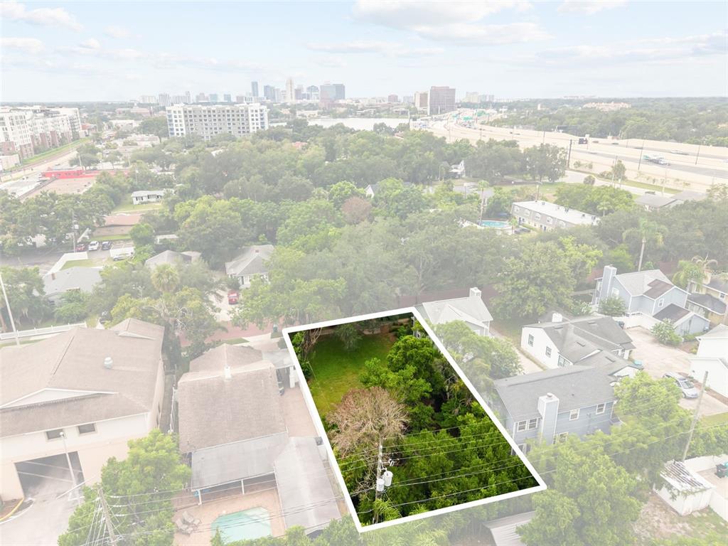 An aerial view highlights a rectangular, tree-filled vacant lot surrounded by residential houses — 311 E YALE STREET, ORLANDO, FL