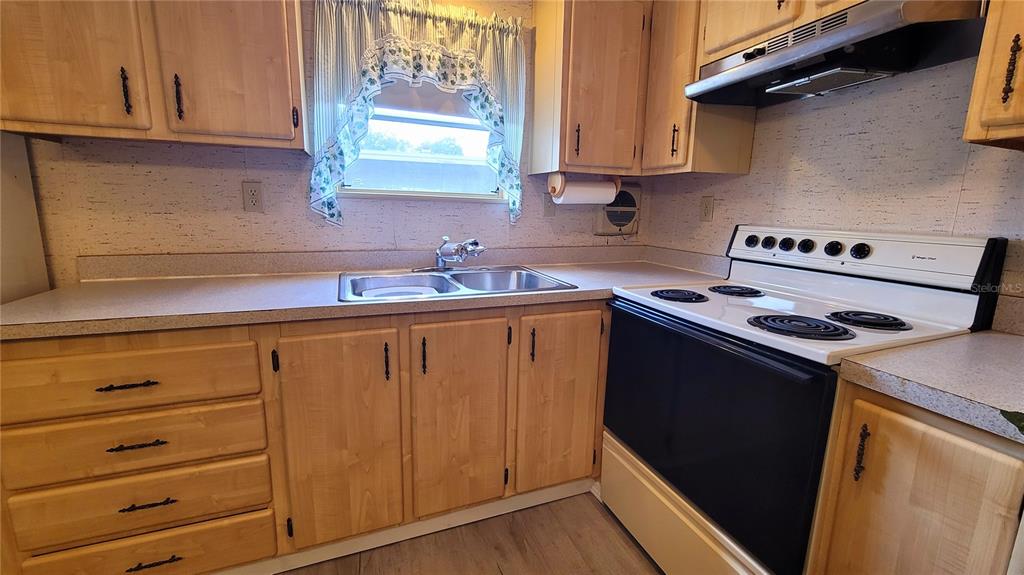 A kitchen features light wood cabinets, a double sink, and a white electric range — 35015 MAJOR DADE, DADE CITY, FL