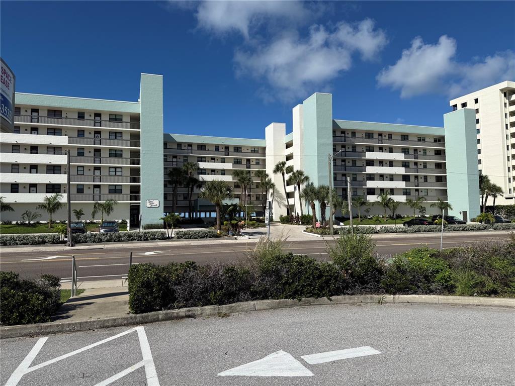 Several colorful kites fly over a sandy beach under a clear blue sky — 14900 GULF BOULEVARD UNIT 113, MADEIRA BEACH, FL