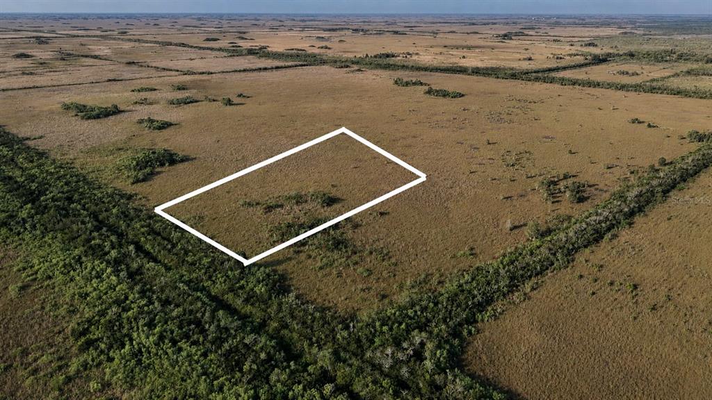 An aerial view shows a rectangular plot of land outlined in white amidst open fields — 0 UNKNOWN ROAD, HOMESTEAD, FL