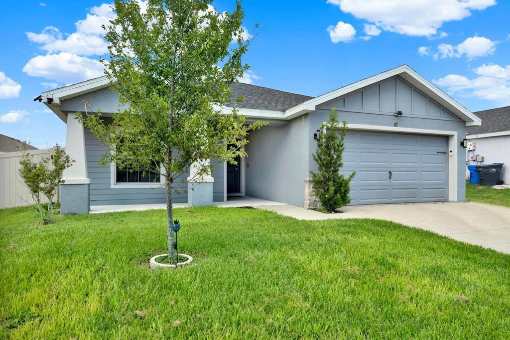 A single-story gray house with a two-car garage and a small front yard — 117 EAGLE SUMMIT DRIVE, RUSKIN, FL