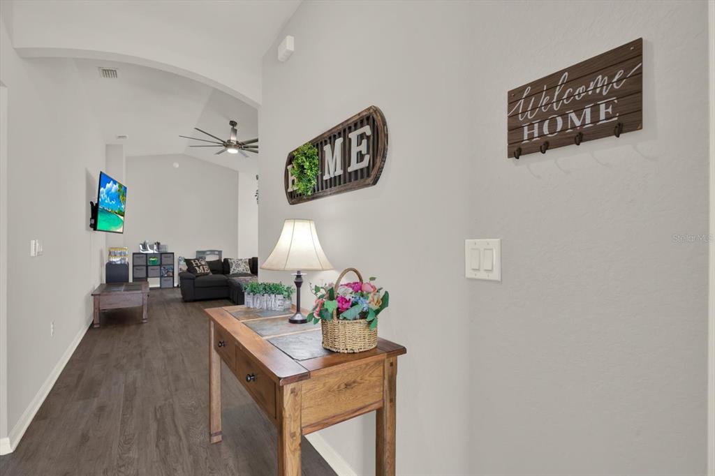 A wooden console table sits in a hallway leading to a living room — 117 EAGLE SUMMIT DRIVE, RUSKIN, FL
