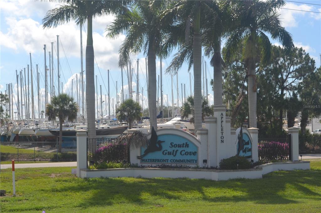 A sign for South Gulf Cove Waterfront Community stands before a marina filled with sailboats — 13598 ALLAMANDA CIRCLE, PORT CHARLOTTE, FL