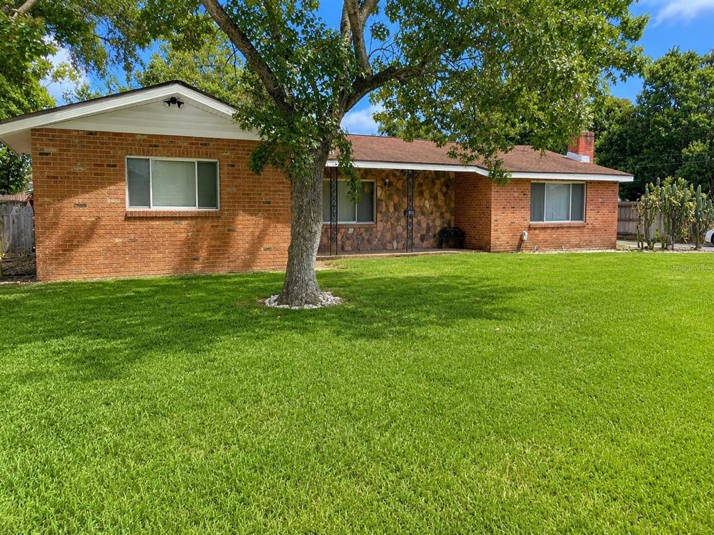 A single-story brick house with a stone facade, a large front tree, and a lawn — 315 LAKE SEMINARY CIRCLE, MAITLAND, FL