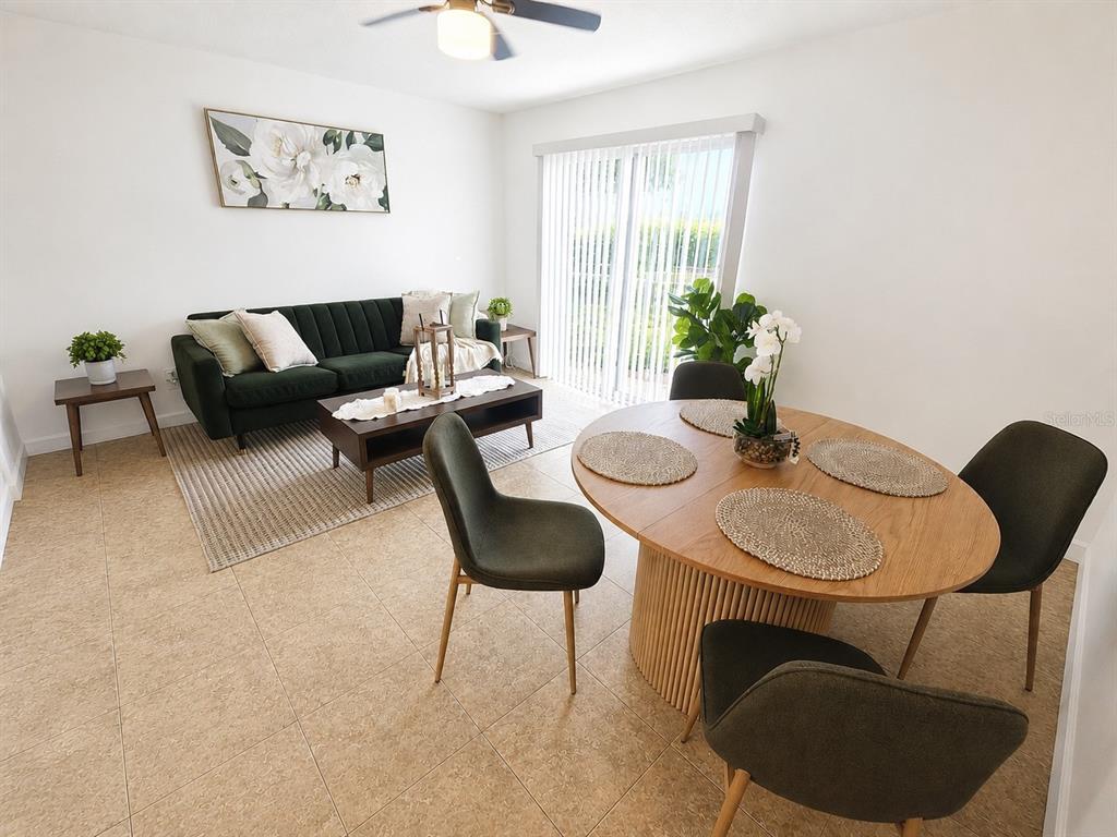 A living and dining area features a green sofa, coffee table, and sliding glass door — 5820 N CHURCH AVENUE UNIT 112, TAMPA, FL