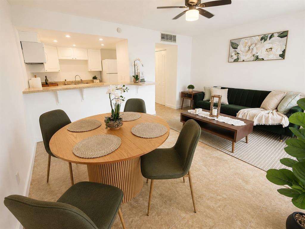 A kitchen featuring white cabinets, a white electric stove, and tan countertops — 5820 N CHURCH AVENUE UNIT 112, TAMPA, FL