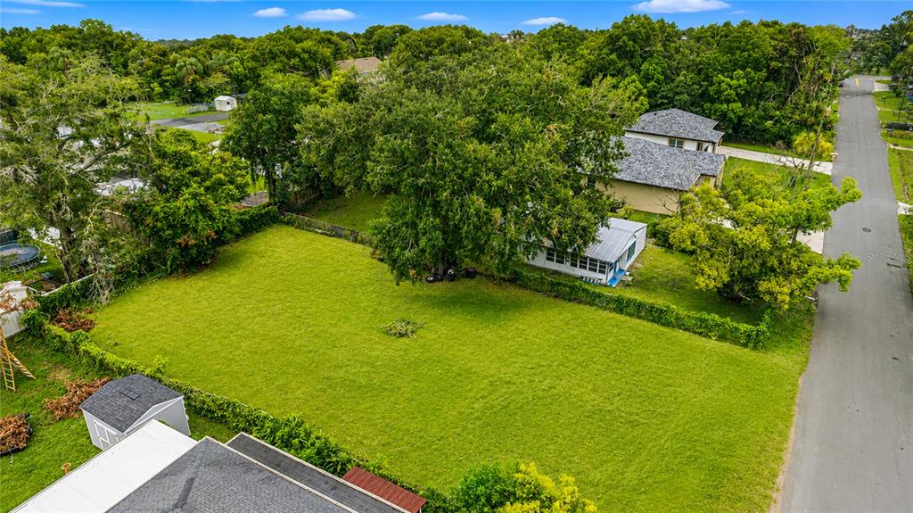 An aerial view shows a large grassy lot with a house and shed — 2743 LUCILLE STREET, KISSIMMEE, FL