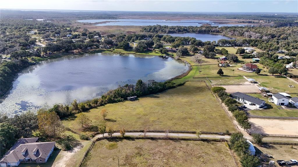 An aerial view shows a large rural property with pastures, buildings, and two lakes — 000 KENNY TRAIL, EUSTIS, FL