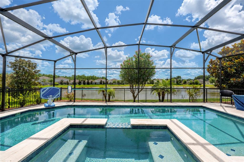 A swimming pool and spa enclosed by a screened lanai overlooking a lake and neighborhood — 1510 CHELSEA MANOR CIRCLE, DELAND, FL
