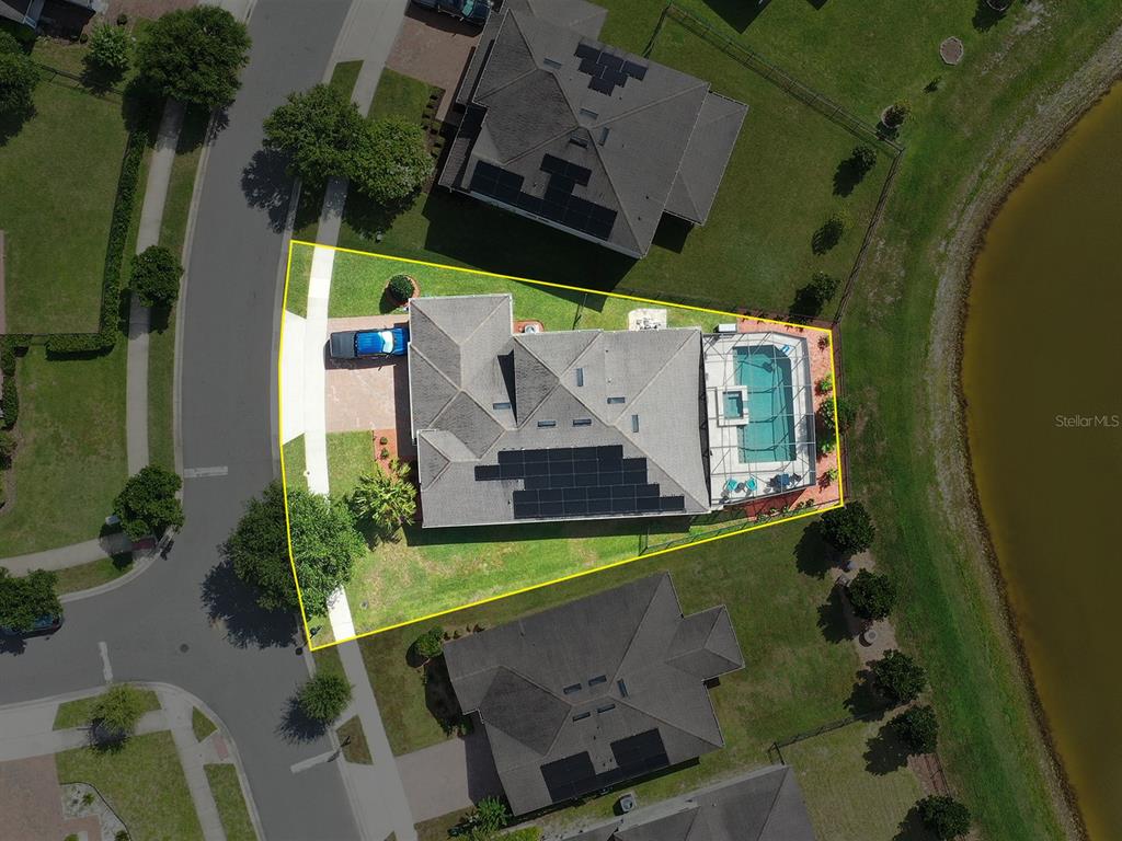 An aerial view shows a house with a pool and solar panels on a corner lot — 1510 CHELSEA MANOR CIRCLE, DELAND, FL