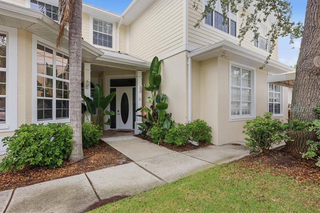 The exterior of a two-story house features light siding, a front walkway, and landscaping — 3409 54TH DRIVE W UNIT 103, BRADENTON, FL