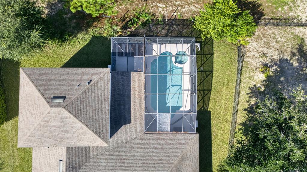 An aerial view of a house with a screened-in pool and spa in the backyard — 219 BLUE HERON COURT, DAVENPORT, FL