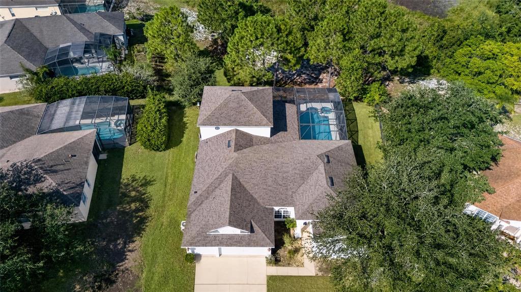 An aerial view shows a suburban house with a screened-in pool and a shingled roof — 219 BLUE HERON COURT, DAVENPORT, FL