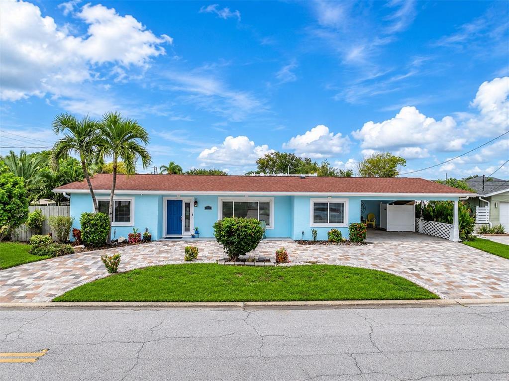 A living room with light blue walls, a fireplace, and a dining area in the background — 7891 4TH AVENUE S, ST PETERSBURG, FL