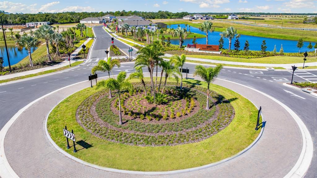 An aerial view of a landscaped roundabout with palm trees in a residential community — 12755 DOCKYARD TRAIL, PALMETTO, FL