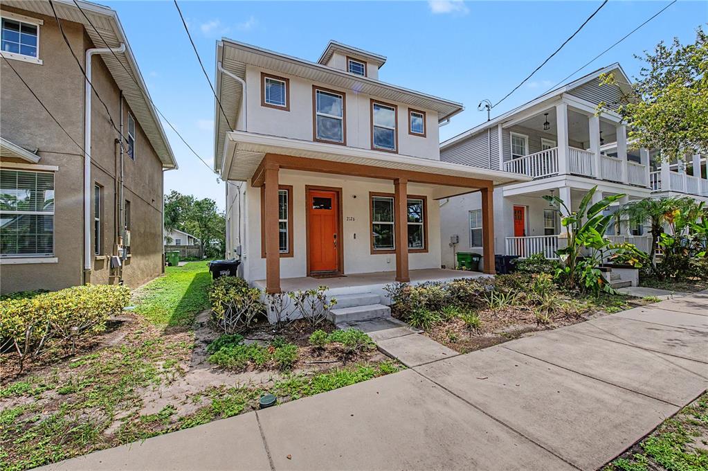 A two-story house with a covered front porch and an orange door — 2126 W SPRUCE STREET, TAMPA, FL