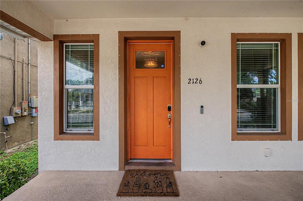 A front entrance features an orange door, two windows, and a cactus-themed welcome mat — 2126 W SPRUCE STREET, TAMPA, FL