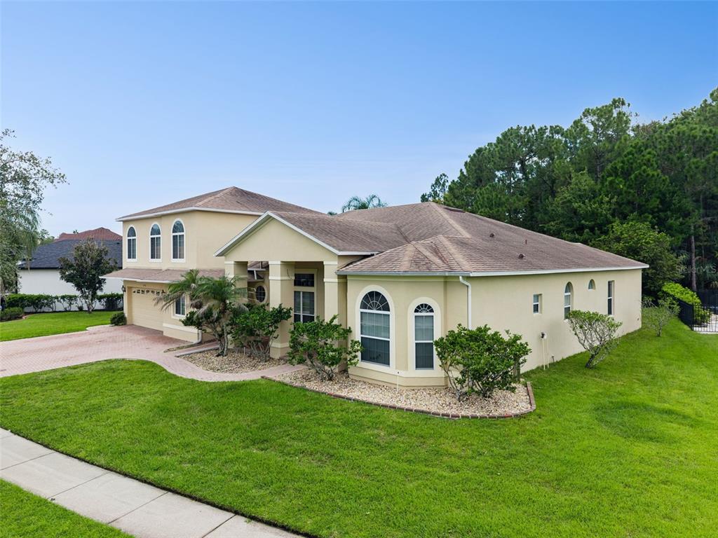 A backyard patio features a stone fire pit, built-in curved benches, and a covered porch — 2436 FAWNLAKE TRAIL, ORLANDO, FL
