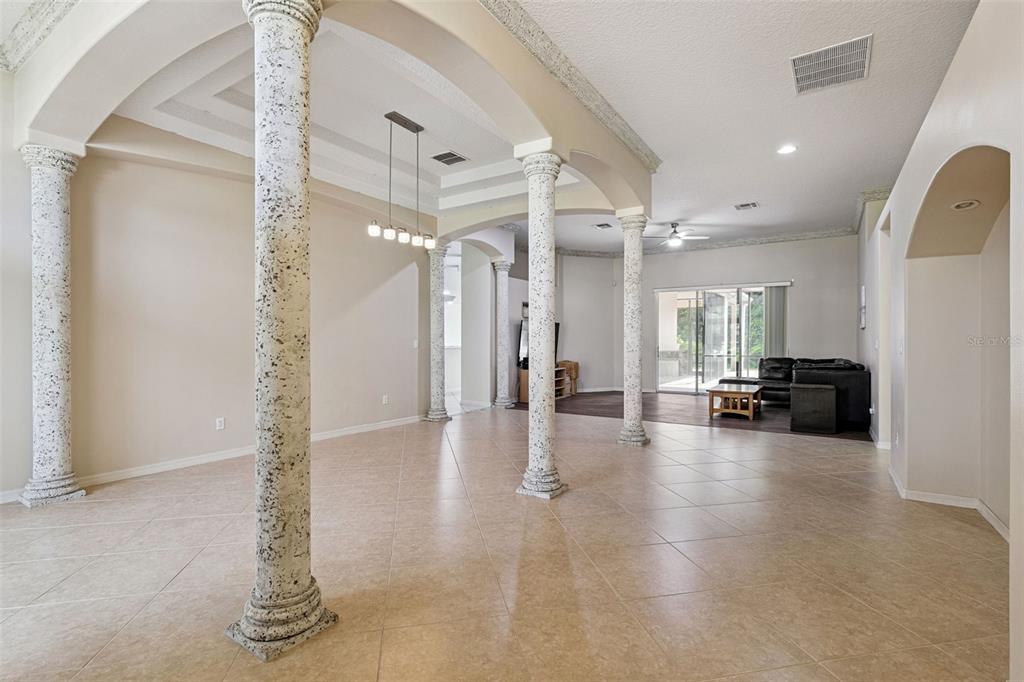 A spacious bedroom features a tray ceiling, neutral carpet, a bed with a bench, and windows — 2436 FAWNLAKE TRAIL, ORLANDO, FL