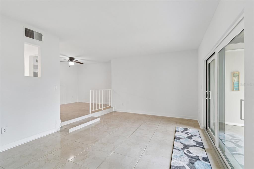 A living area with tile floors, a sunken room, and sliding glass doors — 552 PLAZA SEVILLE COURT UNIT 97, TREASURE ISLAND, FL