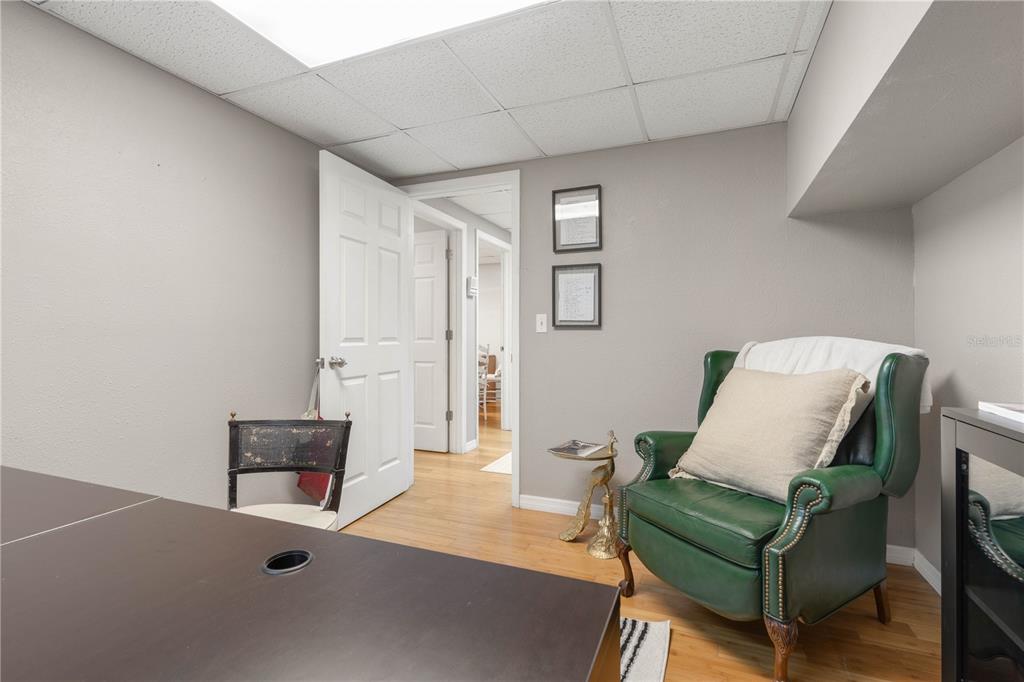 A home office features a green leather armchair, a dark desk, and hardwood flooring — 1291 N US HIGHWAY 1 UNIT 7, ORMOND BEACH, FL