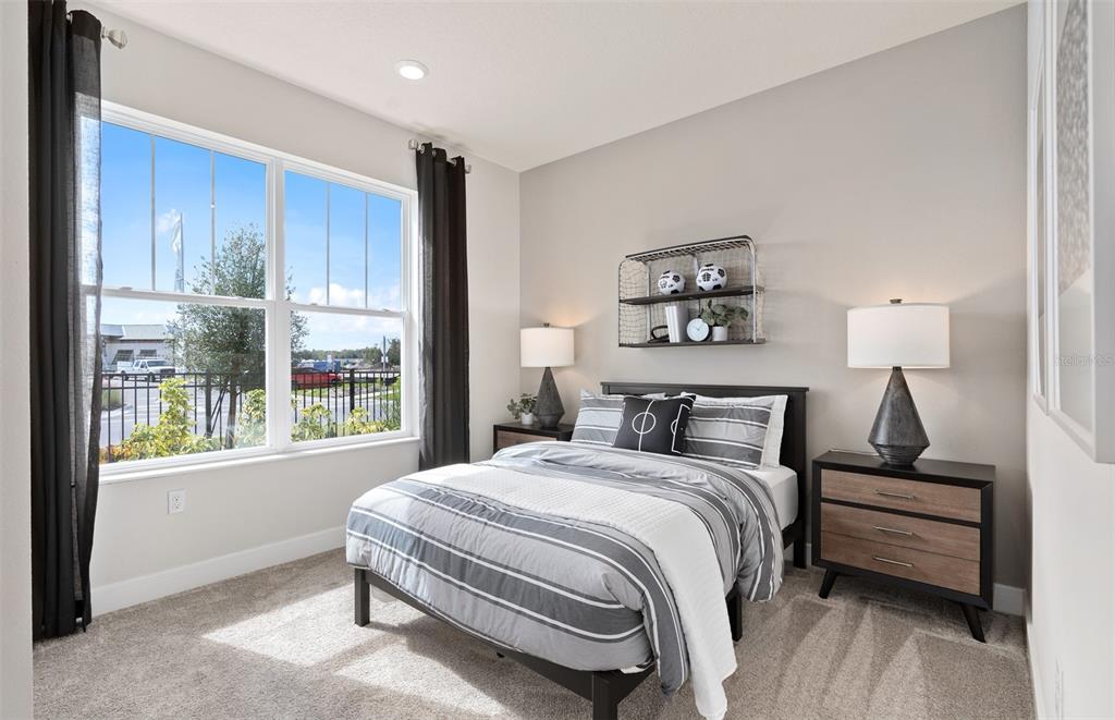 A bedroom features a bed with striped bedding, two nightstands with lamps, and a window — 2697 FERMOY DRIVE, ORMOND BEACH, FL