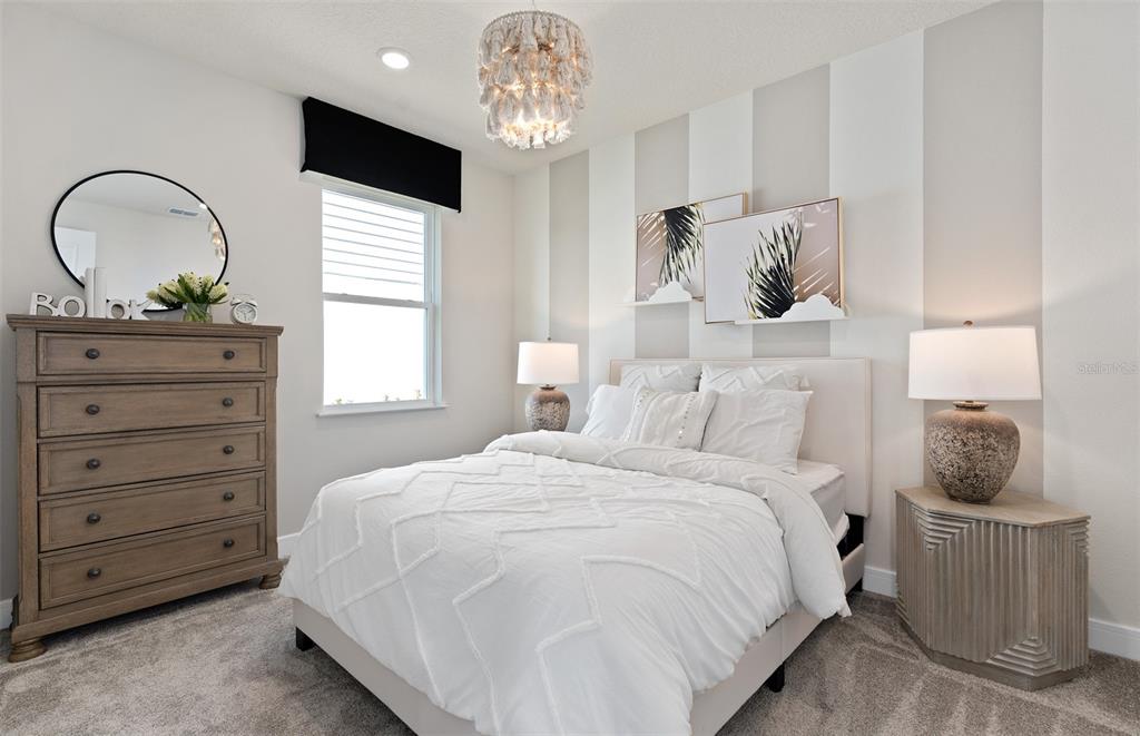 A bedroom features a striped accent wall, a bed with white bedding, and a wooden dresser — 2697 FERMOY DRIVE, ORMOND BEACH, FL