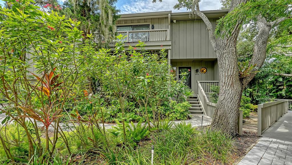 A two-story house with a wooden exterior, a balcony, and a stone walkway entrance — 1372 LANDINGS POINT UNIT 28, SARASOTA, FL