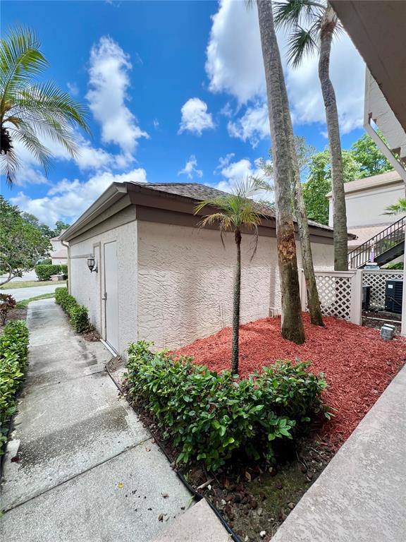 A red convertible is parked in the driveway of a multi-unit residential building — 3014 RED OAK COURT UNIT 102, PALM HARBOR, FL