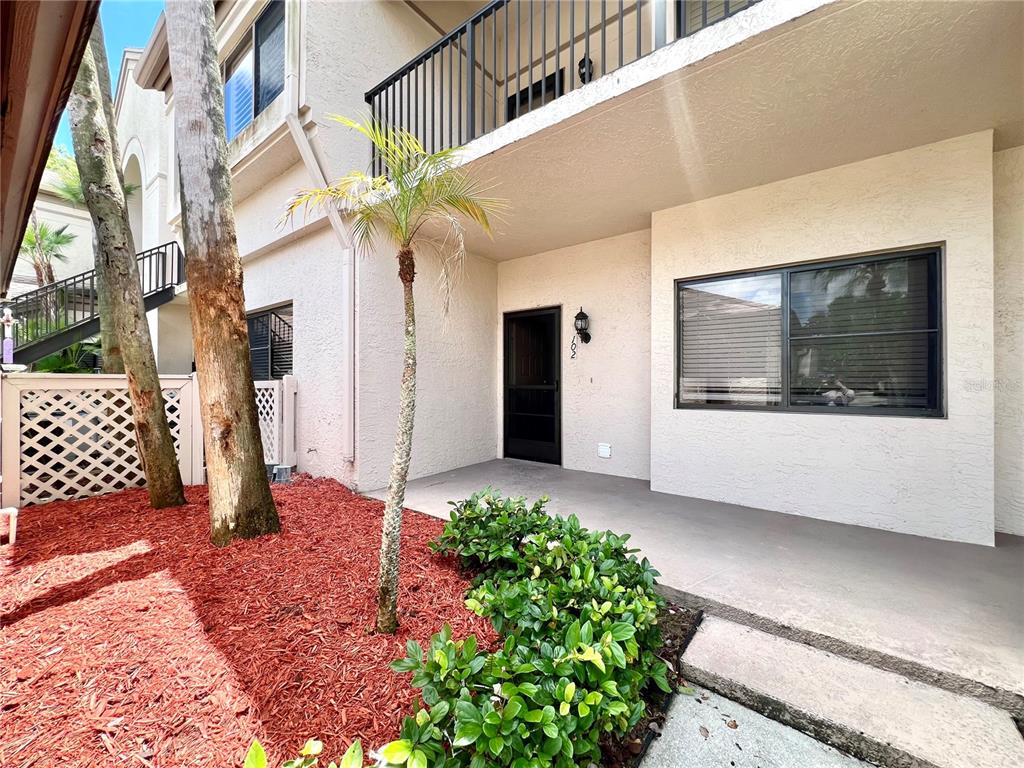 A row of six mailboxes sits on a white wooden stand in front of a house — 3014 RED OAK COURT UNIT 102, PALM HARBOR, FL