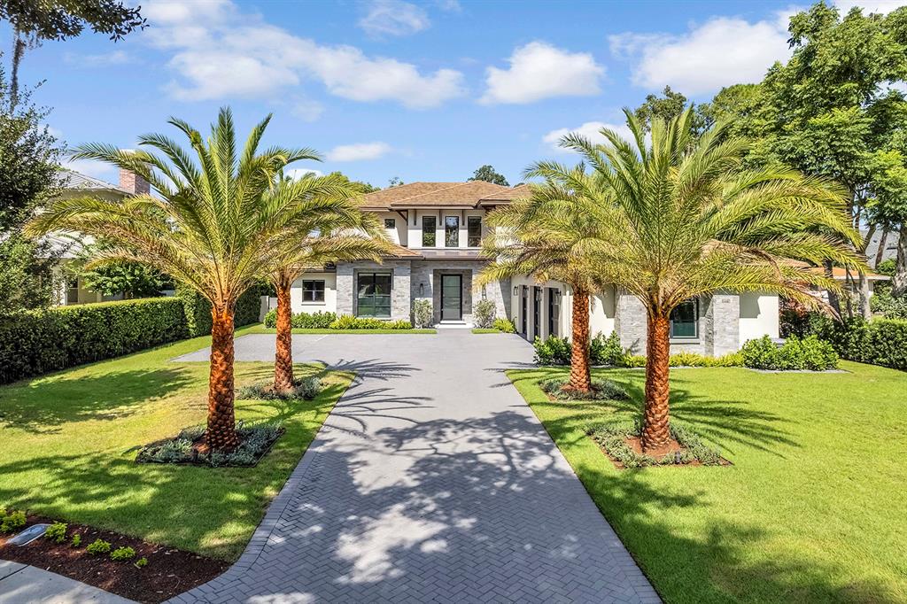 A two-story house with a stone facade, a herringbone driveway, and four prominent palm trees — 901 GOLFVIEW TERRACE, WINTER PARK, FL
