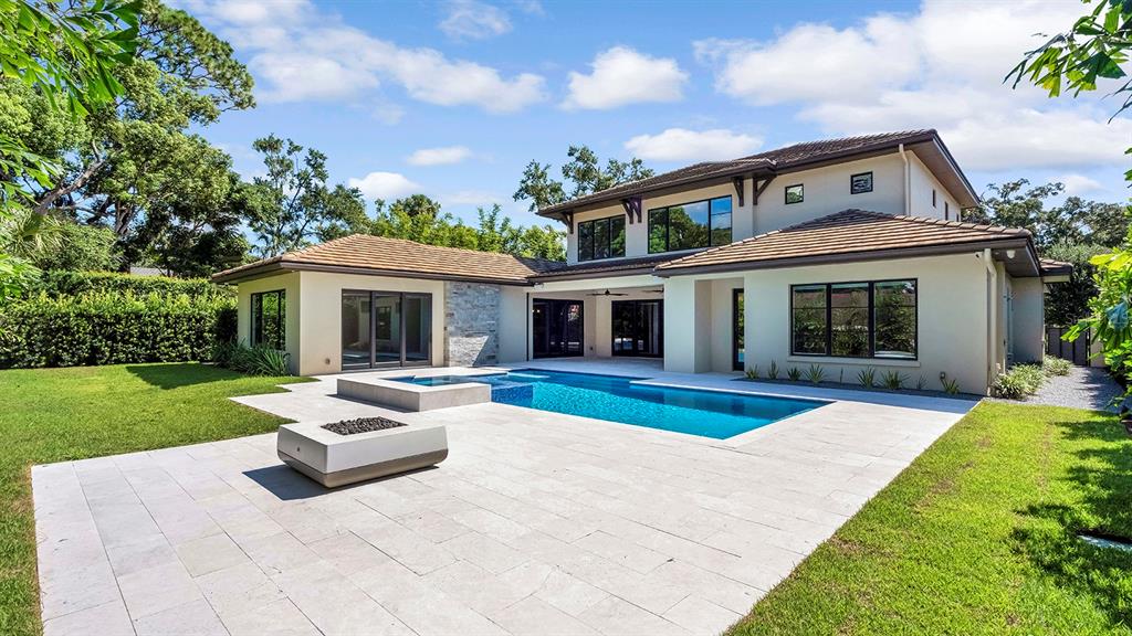 A two-story house with a swimming pool, spa, and stone patio in the backyard — 901 GOLFVIEW TERRACE, WINTER PARK, FL